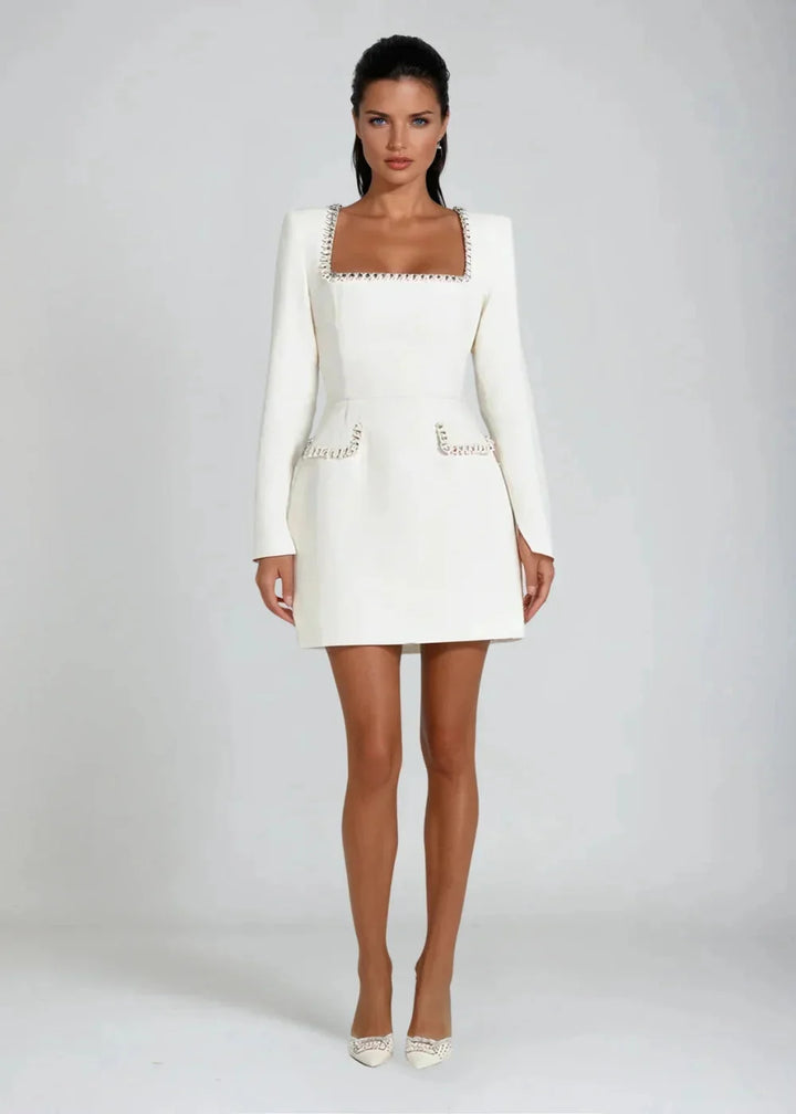 White fitted mini dress with intricate beaded trim detailing. Made from high-quality fabric with a flattering silhouette.