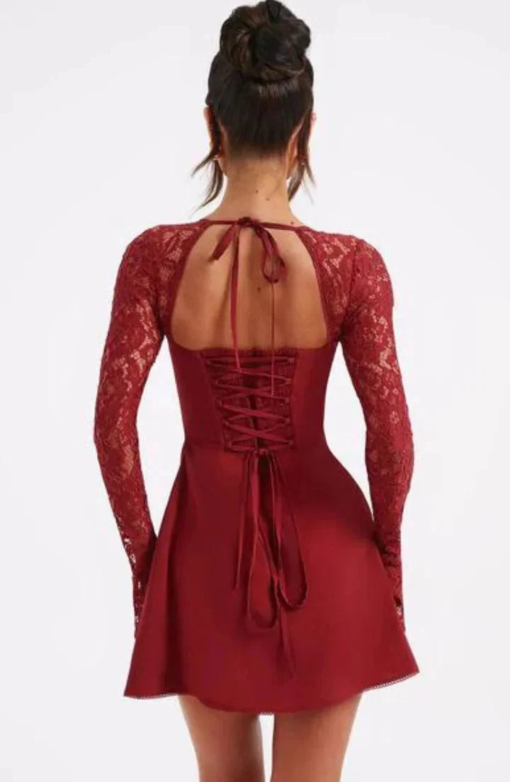 "Black lace mini dress with long sleeves and bow detail, perfect for a chic and elegant look."