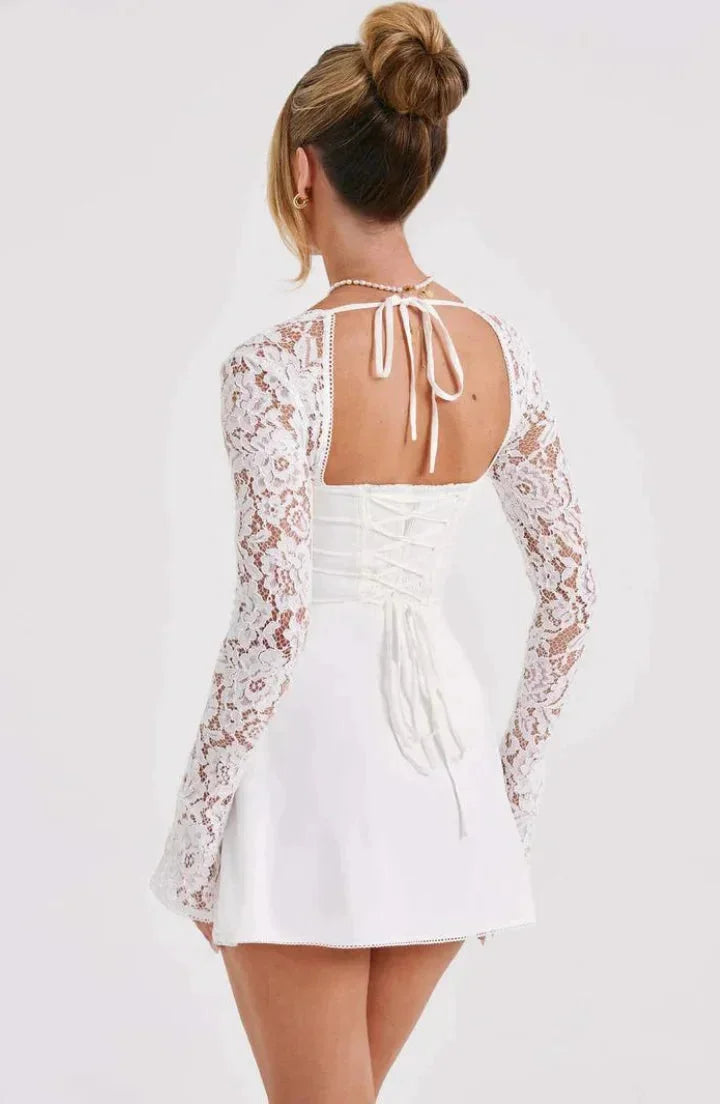 "Layni lace mini dress with bow in black, long sleeves. Feminine and elegant, perfect for special occasions."